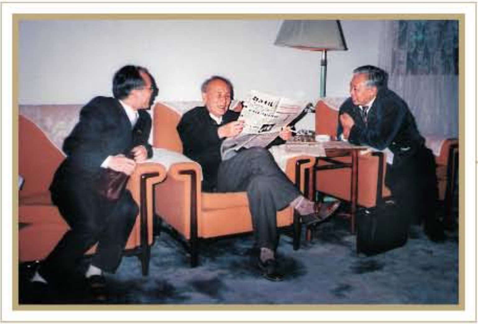 1995年11月16日，本报社长曾广信（左）和副总编肖祥海（右），在长沙拜访时任新华社社长穆青。图为穆青（中）在阅读《邵阳日报》。