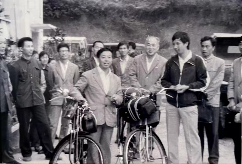 1987年9月，本社记者卢学义、袁通杰骑自行车赴少数民族地区采访，历时58天。图为社领导和同事们在办公楼前，为他俩送行。