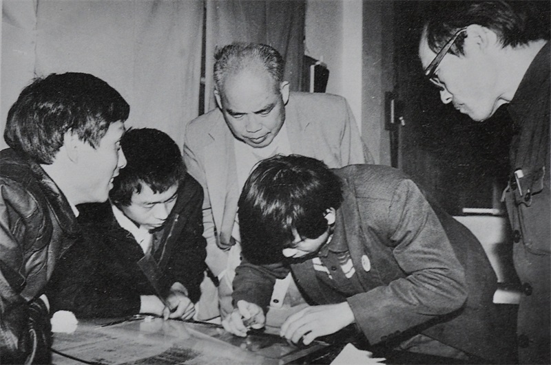 1988年12月31日，本报自行印刷的第一张报纸出版之前，社领导在制版车间了解拼版情况。